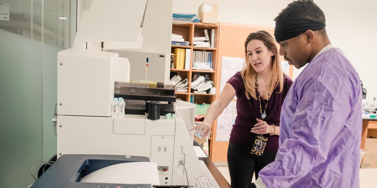 Instructor working with student in medical lab.