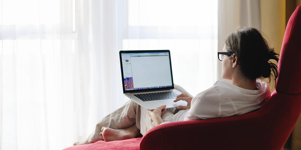 Female student attends class on her laptop at home.