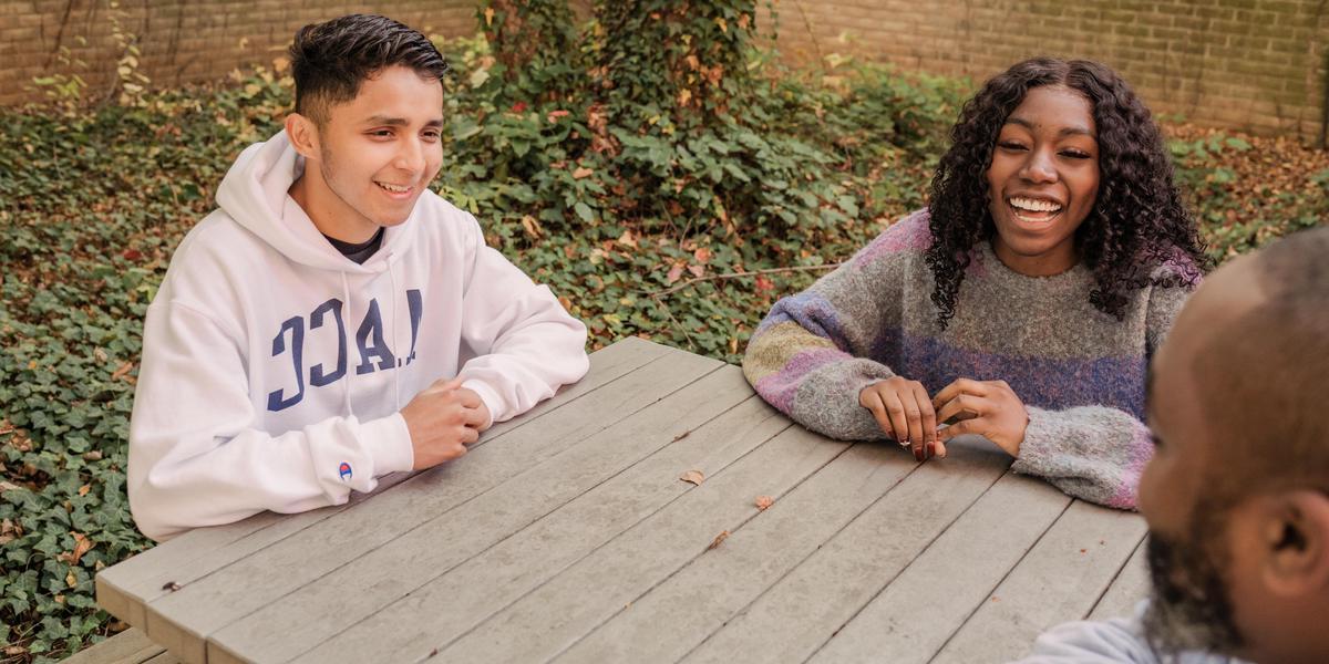 AACC students sitting at picnic table.